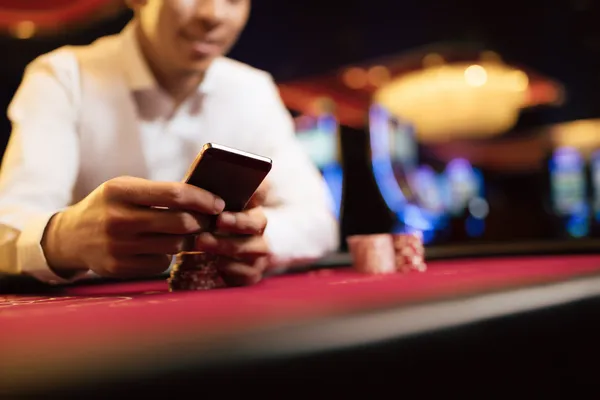 A young woman relaxing with her phone while dynamic casino elements float around her, illustrating the smooth mobile experience offered by the GETA9 app.